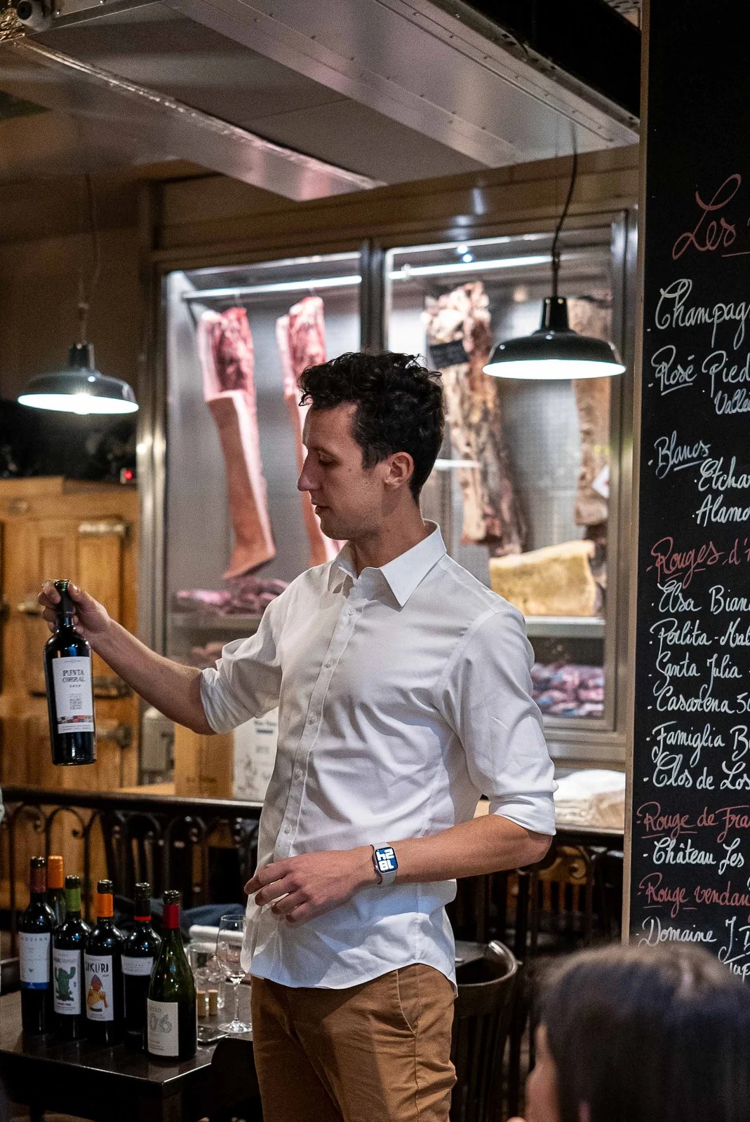 Sommelier présente vin argentin devant ardoise Rouges d'Argentine Rouge de France El Nacional